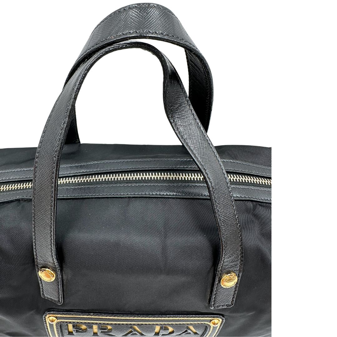 Manici di un bauletto Prada in tessuto vela e dettagli dorati, indossabile a mano, usato, originale, second hand, in ottime condizioni.