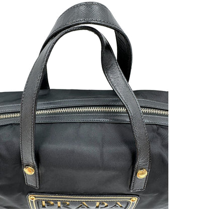 Manici di un bauletto Prada in tessuto vela e dettagli dorati, indossabile a mano, usato, originale, second hand, in ottime condizioni.