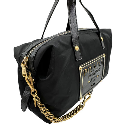 Laterale sinistro di un bauletto Prada in tessuto vela e dettagli dorati, indossabile a mano, usato, originale, second hand, in ottime condizioni.