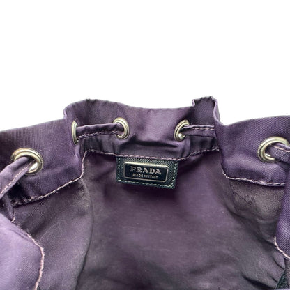 Logo di una pochette Prada in tessuto nylon viola e hardware argentato, usata, originale, second hand, in ottime condizioni.