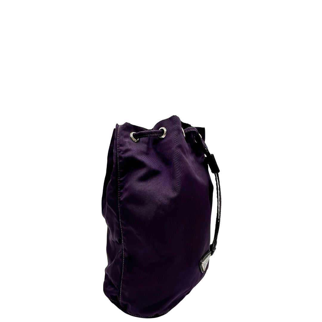 Laterale sinistro di una pochette Prada in tessuto nylon viola e hardware argentato, usata, originale, second hand, in ottime condizioni.