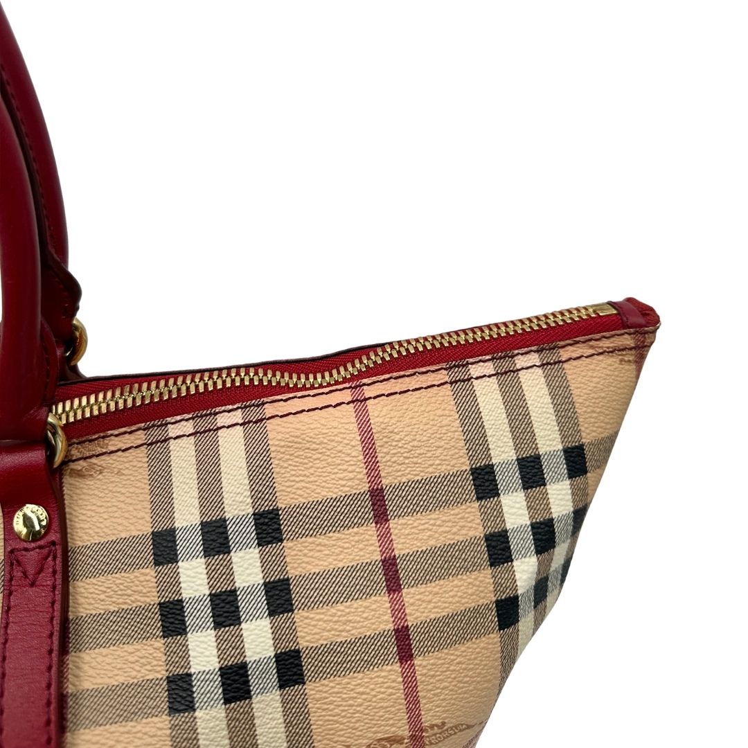 Zip di una shopper Burberry in canvas trama tartan con finiture in pelle bordeaux, usata, originale, second hand, in ottime condizioni.