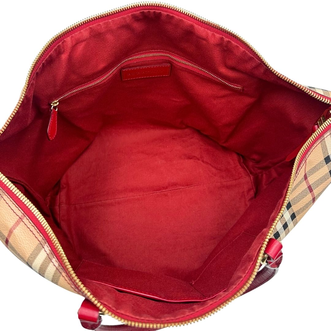 Interno di una shopper Burberry in canvas trama tartan con finiture in pelle bordeaux, usata, originale, second hand, in ottime condizioni.