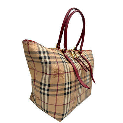 Laterale sinistro di una shopper Burberry in canvas trama tartan con finiture in pelle bordeaux, usata, originale, second hand, in ottime condizioni.