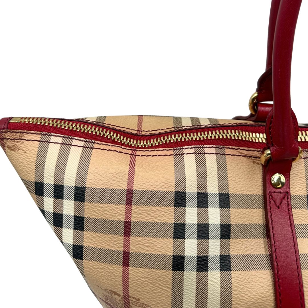 Zip di una shopper Burberry in canvas trama tartan con finiture in pelle bordeaux, usata, originale, second hand, in ottime condizioni.