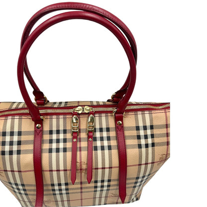 Manici di una shopper Burberry in canvas trama tartan con finiture in pelle bordeaux, usata, originale, second hand, in ottime condizioni.