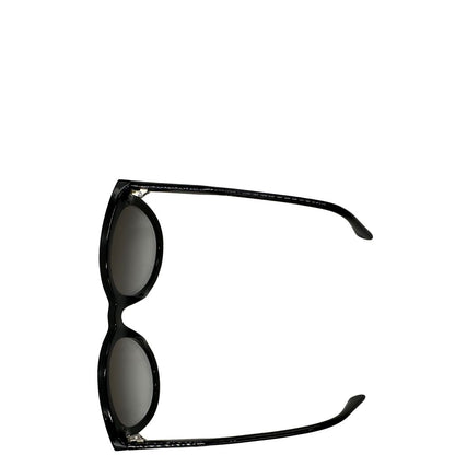 Vista superiore di un paio di occhiali da sole Bottega Veneta in acetato nero con lenti sfumate grigie, usati, originali, second hand, in ottime condizioni.