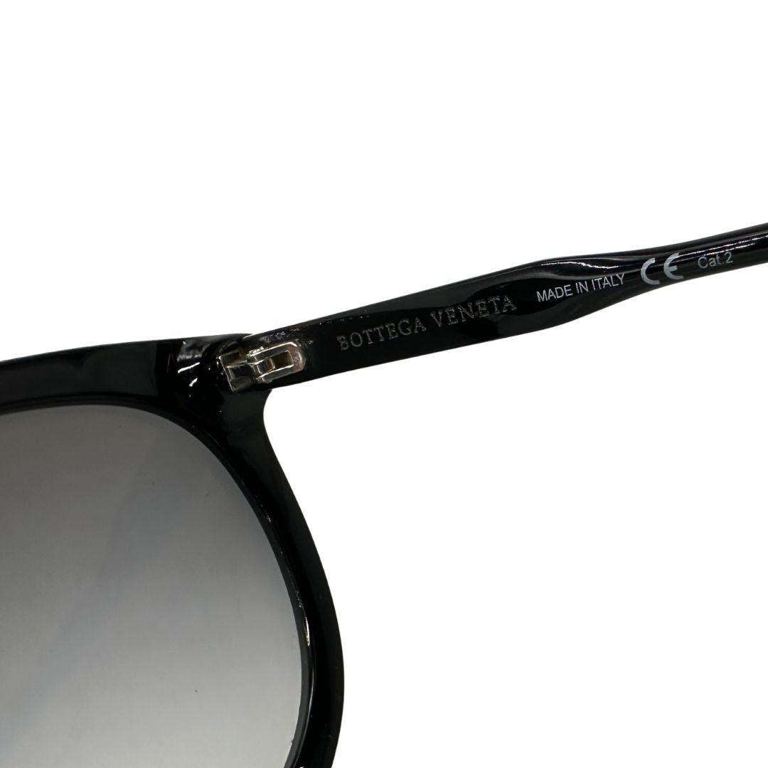 Logo di un paio di occhiali da sole Bottega Veneta in acetato nero con lenti sfumate grigie, usati, originali, second hand, in ottime condizioni.