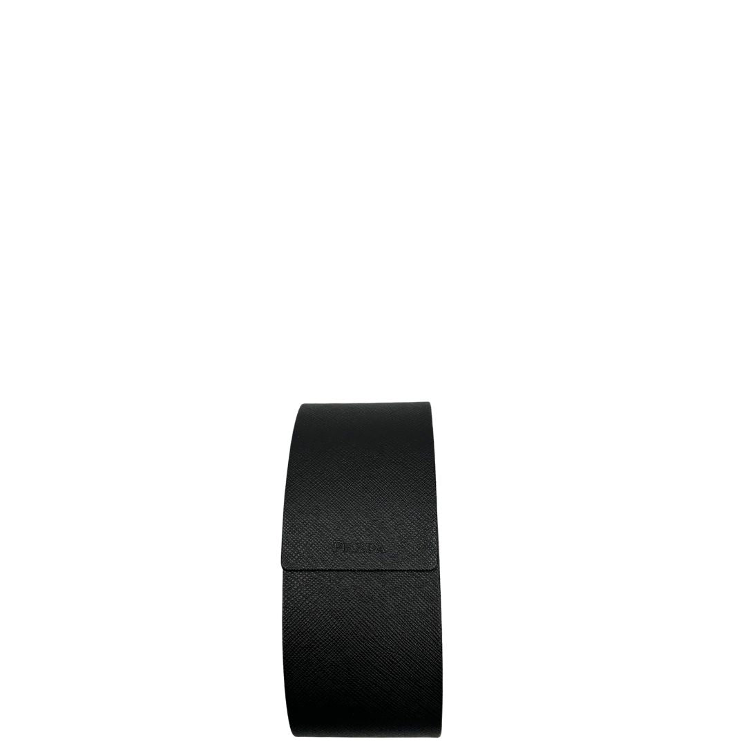 Custodia di un paio di occhiali da sole Prada caratterizzati da una montatura nera lucida con lenti sfumate grigie, asticelle maculate e hardware dorato, usati, originali, second hand, in ottime condizioni.
