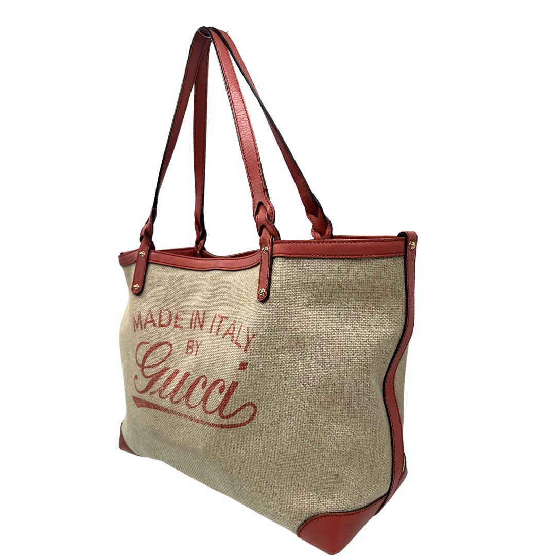 Laterale destro di una shopper Gucci Craft in tela beige, con finiture in pelle color rosa corallo. Dotata anche di una comoda pochette estraibile, usata, originale, second hand, in ottime condizioni.