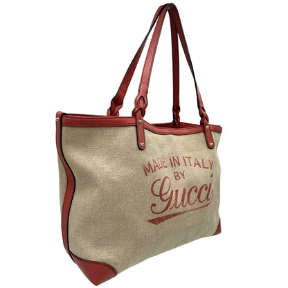 Laterale sinistro di una shopper Gucci Craft in tela beige, con finiture in pelle color rosa corallo. Dotata anche di una comoda pochette estraibile, usata, originale, second hand, in ottime condizioni.