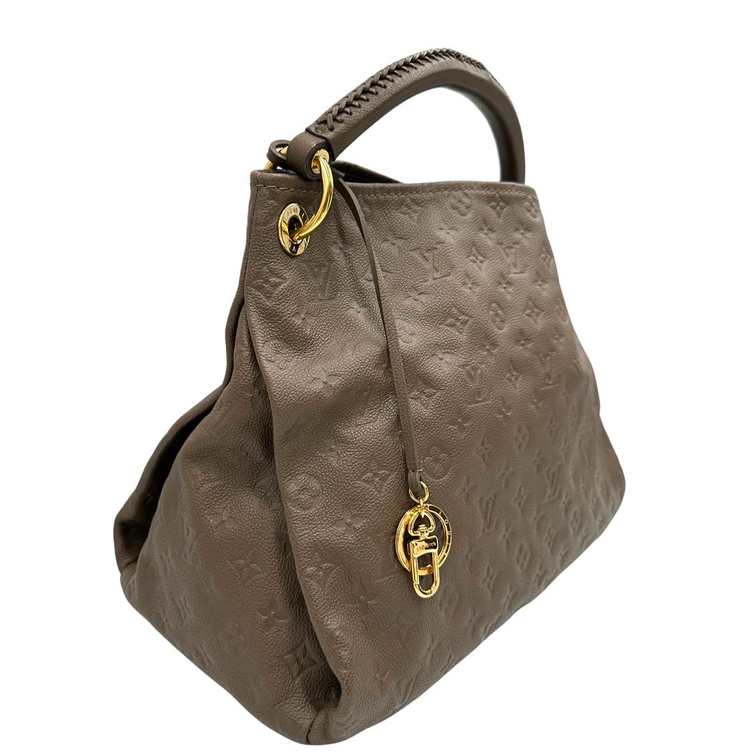 Laterale sinsitro di una borsa Artsy Louis Vuitton nella versione MM in una calda tonalità color nocciola, corredata, usata, originale, second hand, in ottime condizioni.