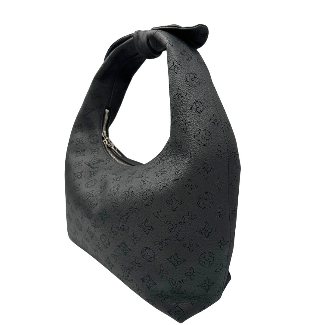 Laterale destro di una borsa hobo LV Mahina Why Knot nera in monogram mahina, con iconico maxi fiocco sulla parte superiore, usata, originale, second hand, in condizioni eccellenti.
