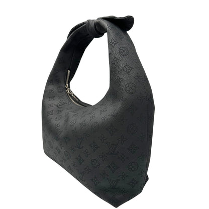 Laterale destro di una borsa hobo LV Mahina Why Knot nera in monogram mahina, con iconico maxi fiocco sulla parte superiore, usata, originale, second hand, in condizioni eccellenti.