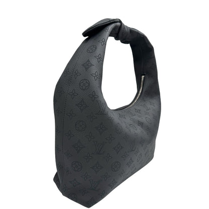 Laterale sinistro di una borsa hobo LV Mahina Why Knot nera in monogram mahina, con iconico maxi fiocco sulla parte superiore, usata, originale, second hand, in condizioni eccellenti.