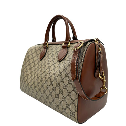 Laterale destro di un bauletto Gucci GG in canvas beige, con parti in pelle marroni, usato, originale, second hand, in ottime condizioni.