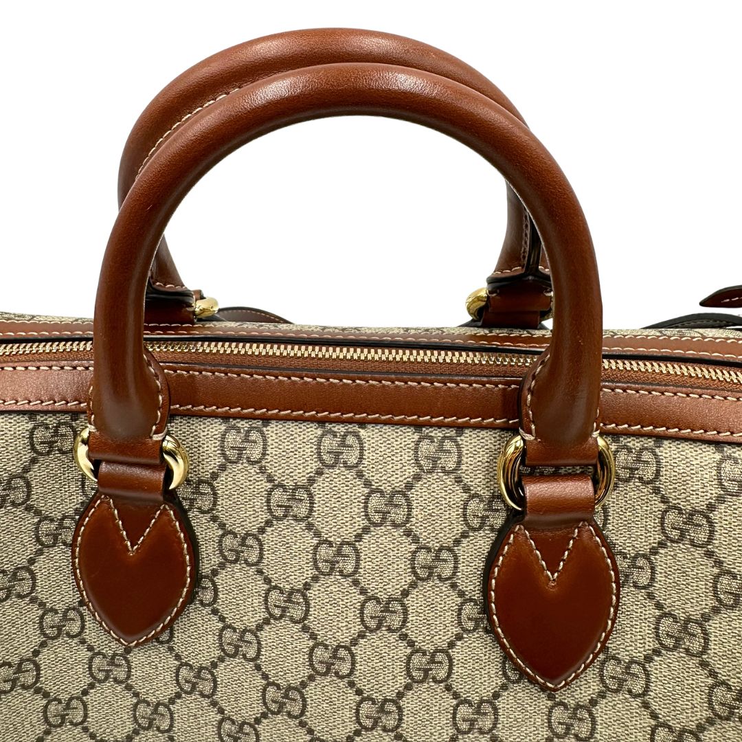 Manici di un bauletto Gucci GG in canvas beige, con parti in pelle marroni, usato, originale, second hand, in ottime condizioni.