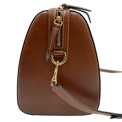 Vista laterale di un bauletto Gucci GG in canvas beige, con parti in pelle marroni, usato, originale, second hand, in ottime condizioni.