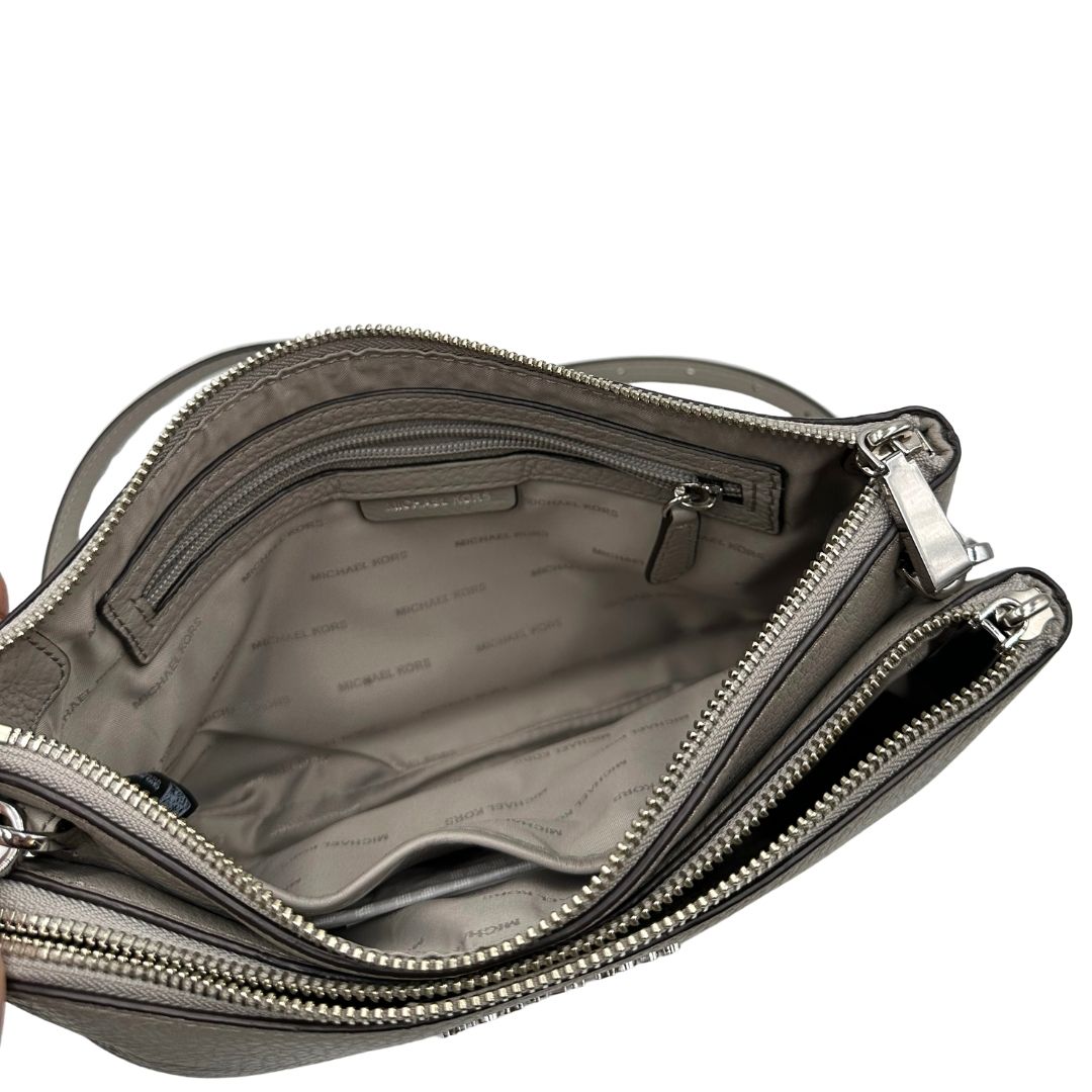 Interno, Tracolla MK versatile in pelle martellata grigio chiaro caratterizzata da una struttura funzionale a più scomparti con hardware argentato.