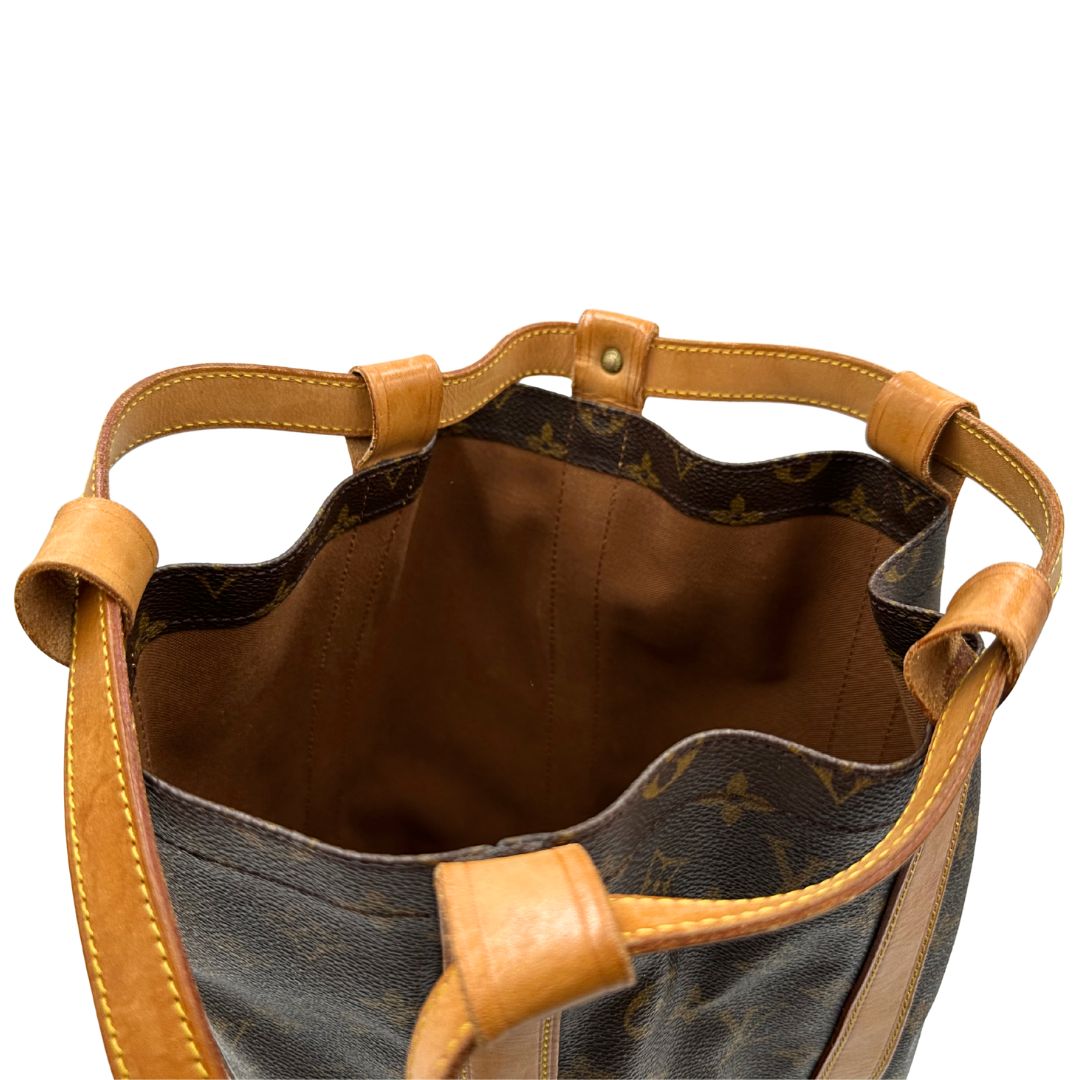 Chiusura, Zaino Louis Vuitton realizzato in tela Monogram con hardware dorato, caratterizzato da una chiusura a coulisse. Indossabile a spalla.