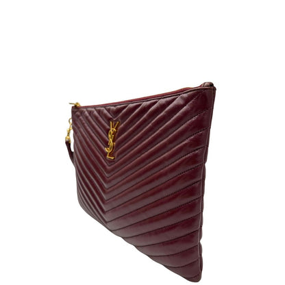 Laterale destro di una pochette Saint Laurent in pelle bordeaux trapuntata, con parti metalliche dorate, usata, originale, second hand, in ottime condizioni.