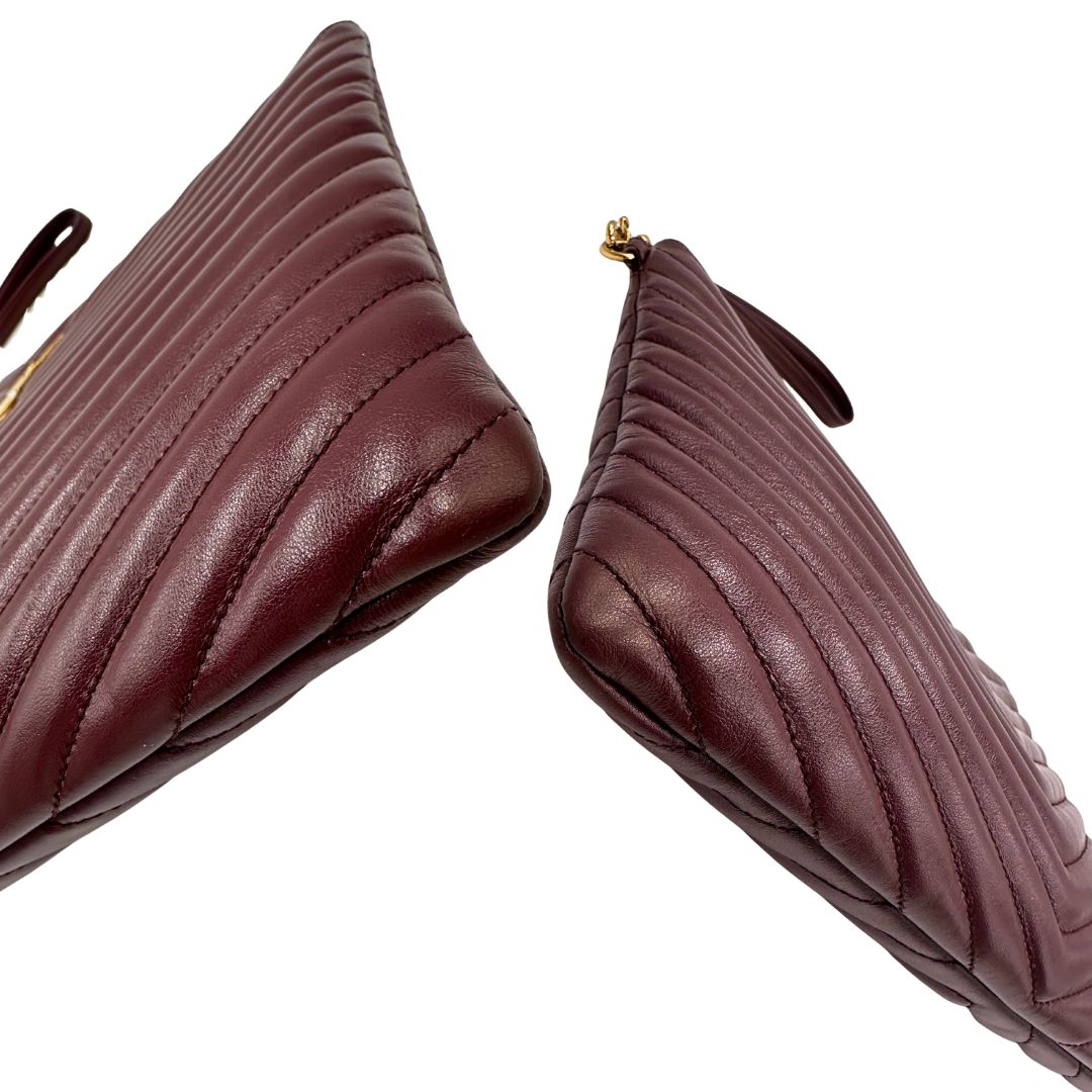 Angoli di una pochette Saint Laurent in pelle bordeaux trapuntata, con parti metalliche dorate, usata, originale, second hand, in ottime condizioni.