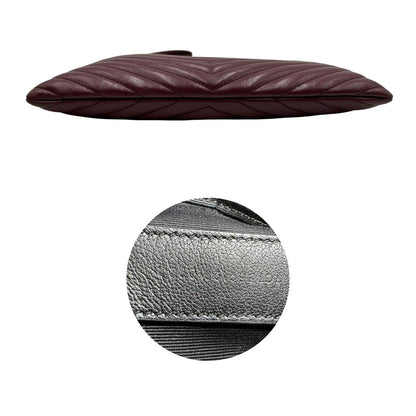 Base e codice di una pochette Saint Laurent in pelle bordeaux trapuntata, con parti metalliche dorate, usata, originale, second hand, in ottime condizioni.