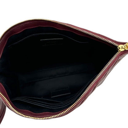 Interno di una pochette Saint Laurent in pelle bordeaux trapuntata, con parti metalliche dorate, usata, originale, second hand, in ottime condizioni.