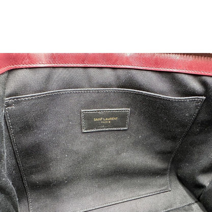 Interno di una pochette Saint Laurent in pelle bordeaux trapuntata, con parti metalliche dorate, usata, originale, second hand, in ottime condizioni.