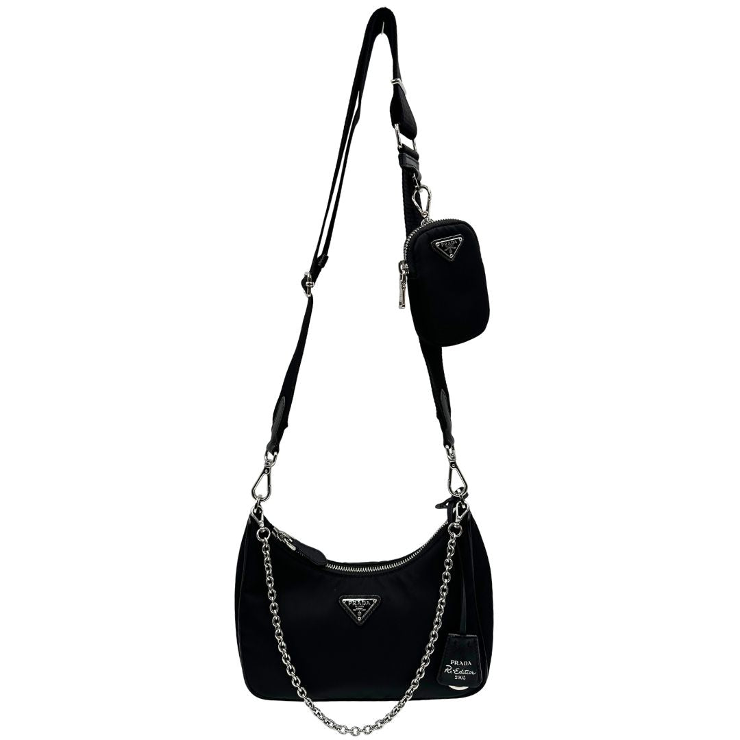 Front di una borsa Prada Re-Edition 2005 in nylon nero con dettagli in pelle e hardware argento, arricchita da catena frontale, mini pouch removibile e portachiavi logato. Modello compatto e versatile, utilizzabile a spalla, a mano o crossbody, usata, originale, second hand, in condizioni eccellenti.