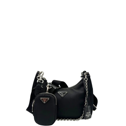 Front di una borsa Prada Re-Edition 2005 in nylon nero con dettagli in pelle e hardware argento, arricchita da catena frontale, mini pouch removibile e portachiavi logato. Modello compatto e versatile, utilizzabile a spalla, a mano o crossbody, usata, originale, second hand, in condizioni eccellenti.