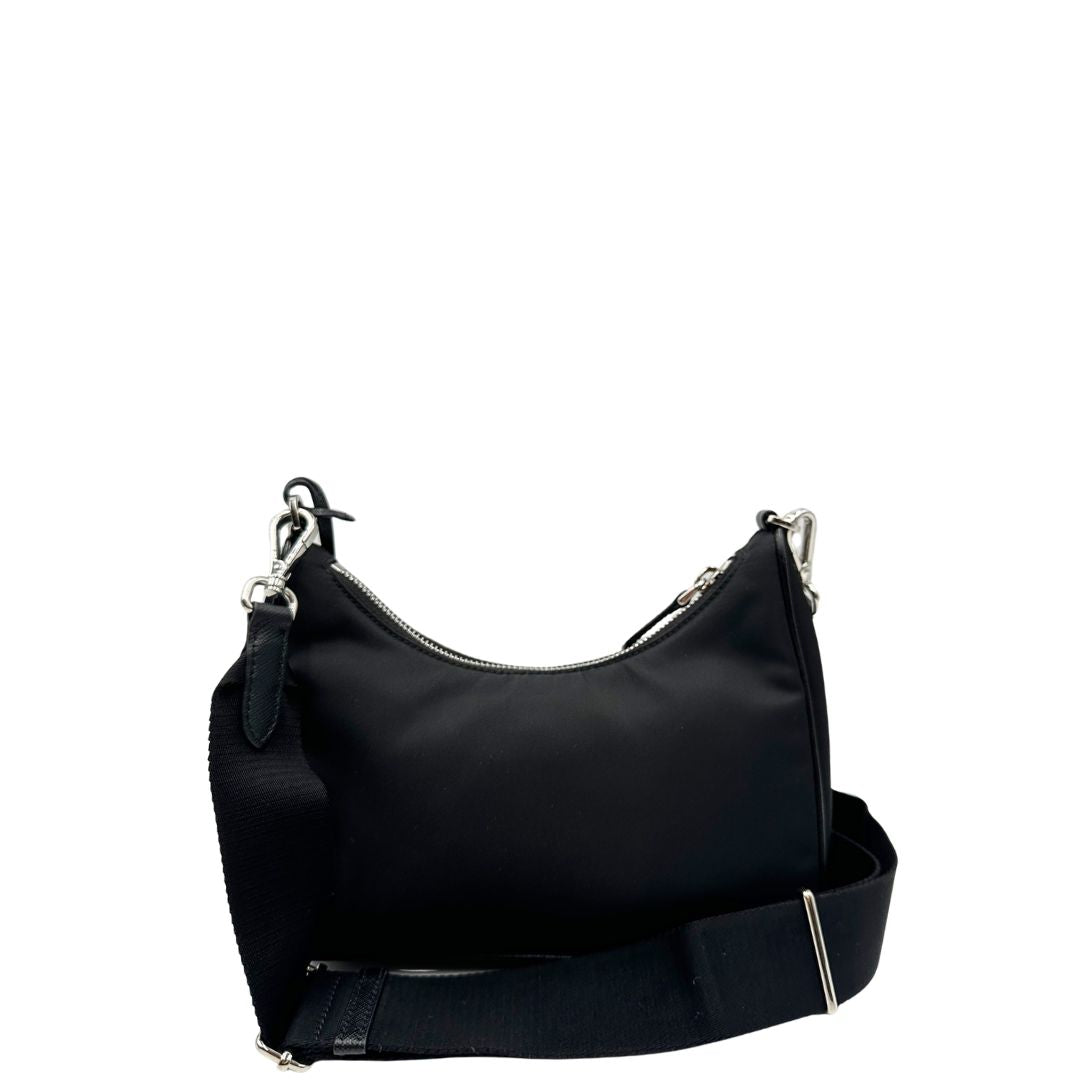 Retro di una borsa Prada Re-Edition 2005 in nylon nero con dettagli in pelle e hardware argento, arricchita da catena frontale, mini pouch removibile e portachiavi logato. Modello compatto e versatile, utilizzabile a spalla, a mano o crossbody, usata, originale, second hand, in condizioni eccellenti.
