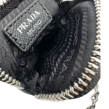 Interno di una pouch amovibile di una borsa Prada Re-Edition 2005 in nylon nero con dettagli in pelle e hardware argento, arricchita da catena frontale e portachiavi logato. Modello compatto e versatile, utilizzabile a spalla, a mano o crossbody, usata, originale, second hand, in condizioni eccellenti.