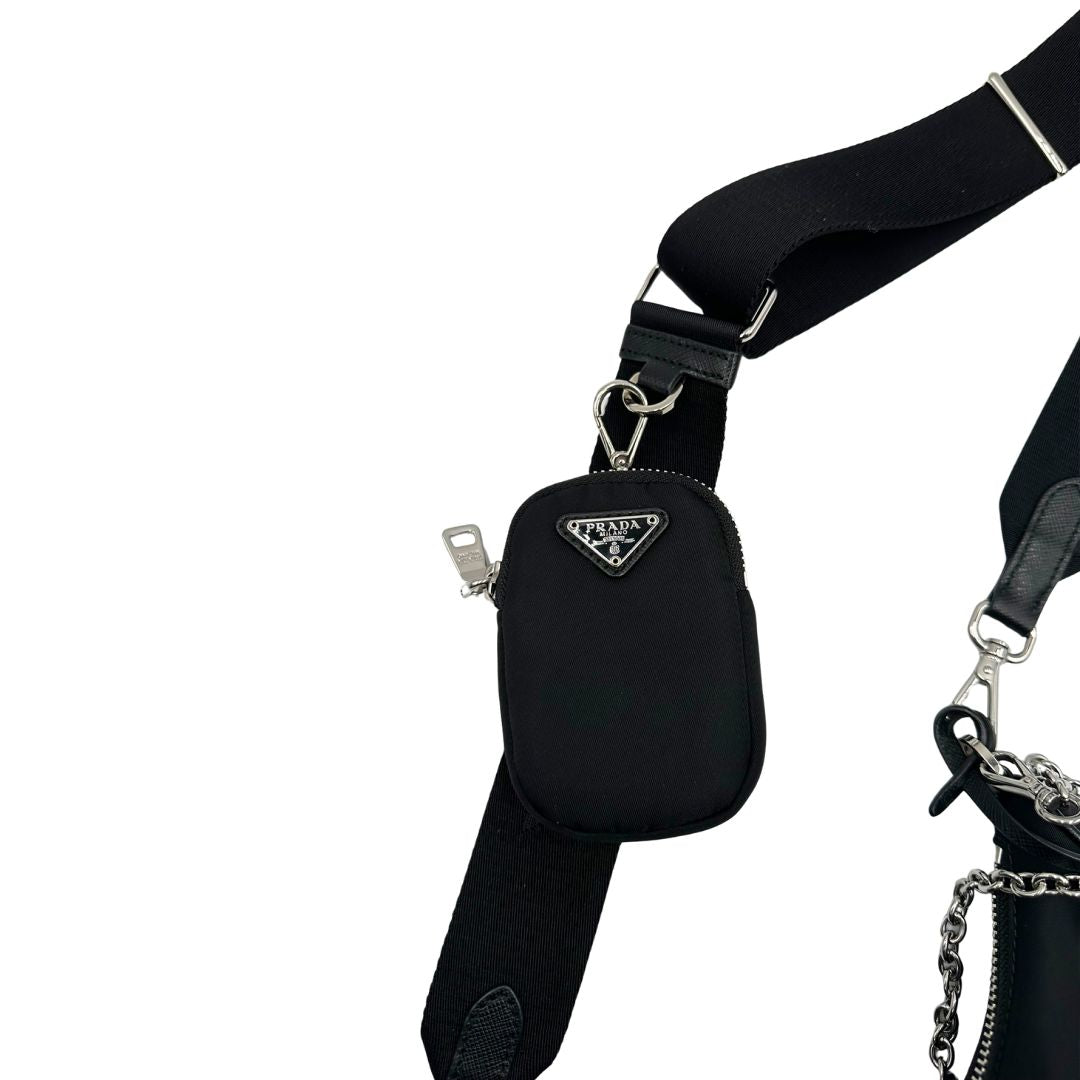 Pouch amovibile di una borsa Prada Re-Edition 2005 in nylon nero con dettagli in pelle e hardware argento, arricchita da catena frontale e portachiavi logato. Modello compatto e versatile, utilizzabile a spalla, a mano o crossbody, usata, originale, second hand, in condizioni eccellenti.