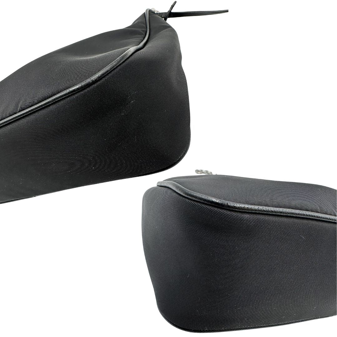 Angoli di una borsa Prada Re-Edition 2005 in nylon nero con dettagli in pelle e hardware argento, arricchita da catena frontale, mini pouch removibile e portachiavi logato. Modello compatto e versatile, utilizzabile a spalla, a mano o crossbody, usata, originale, second hand, in condizioni eccellenti.