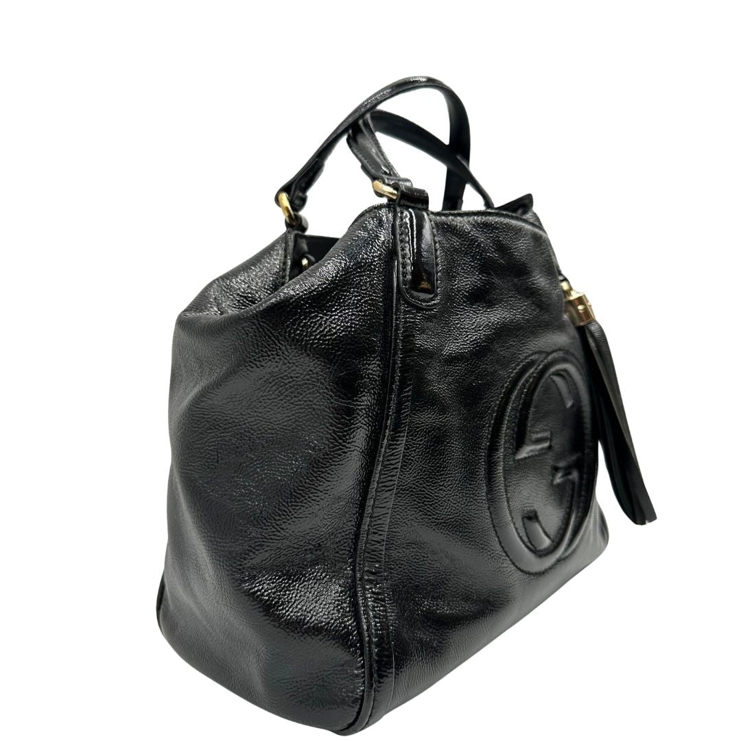 Lato destro, Borsa Gucci Soho in pelle verniciata nera con logo Soho in rilievo e parti metalliche dorate; da indossare a mano oppure a mano. Originale, usata, di lusso, in ottime condizioni.