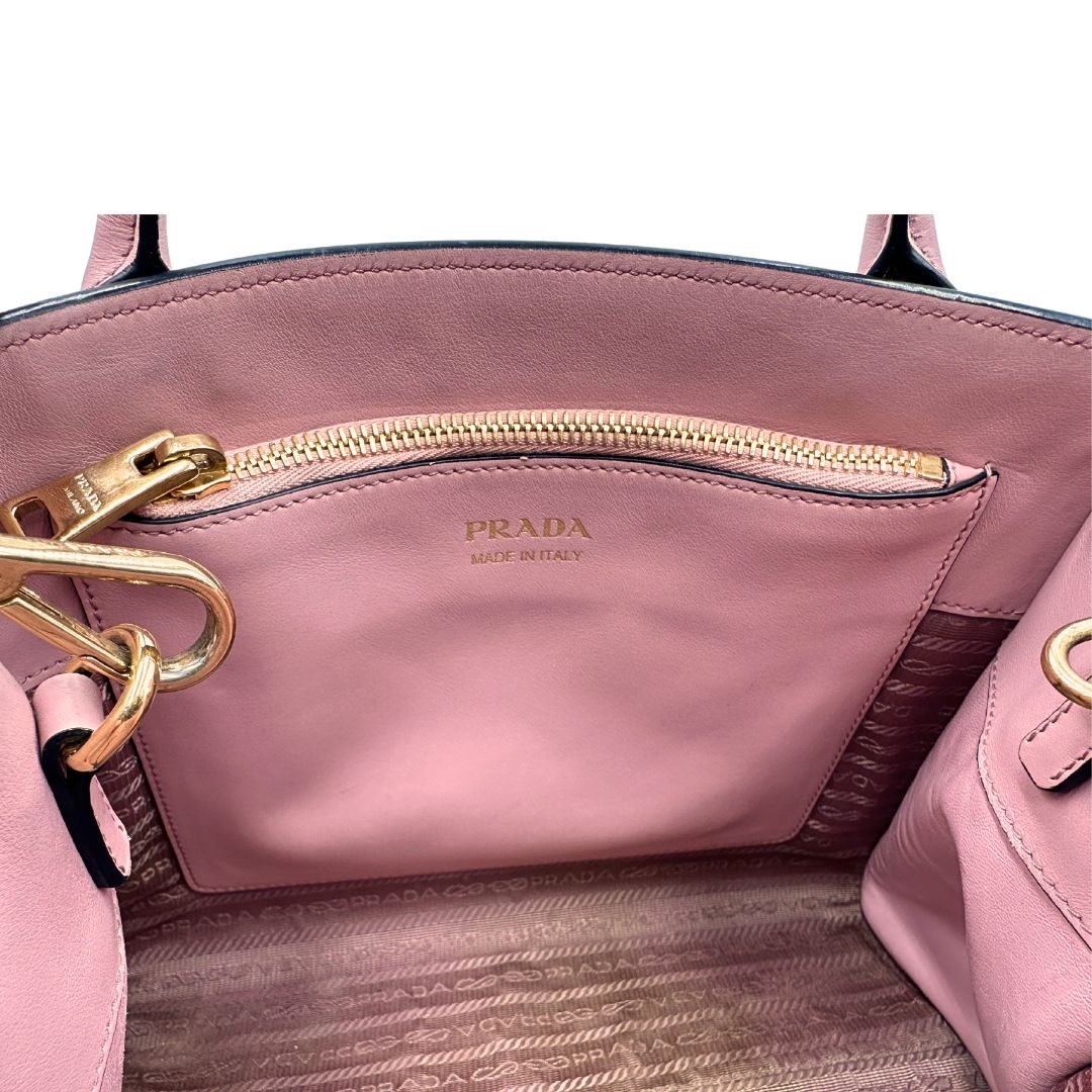 Interno di una borsa Prada rosa in pelle saffiano, dotata di un pratico charm con specchietto amovibile, usata, originale, second hand, in ottime condizioni.