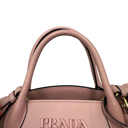Manici di una borsa Prada rosa in pelle saffiano, dotata di un pratico charm con specchietto amovibile, usata, originale, second hand, in ottime condizioni.