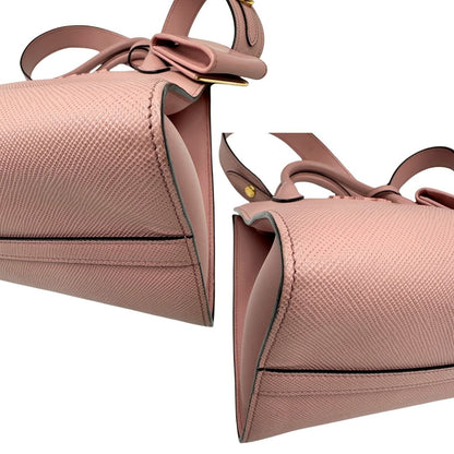 Angoli di una borsa Prada rosa in pelle saffiano, dotata di un pratico charm con specchietto amovibile, usata, originale, second hand, in ottime condizioni.