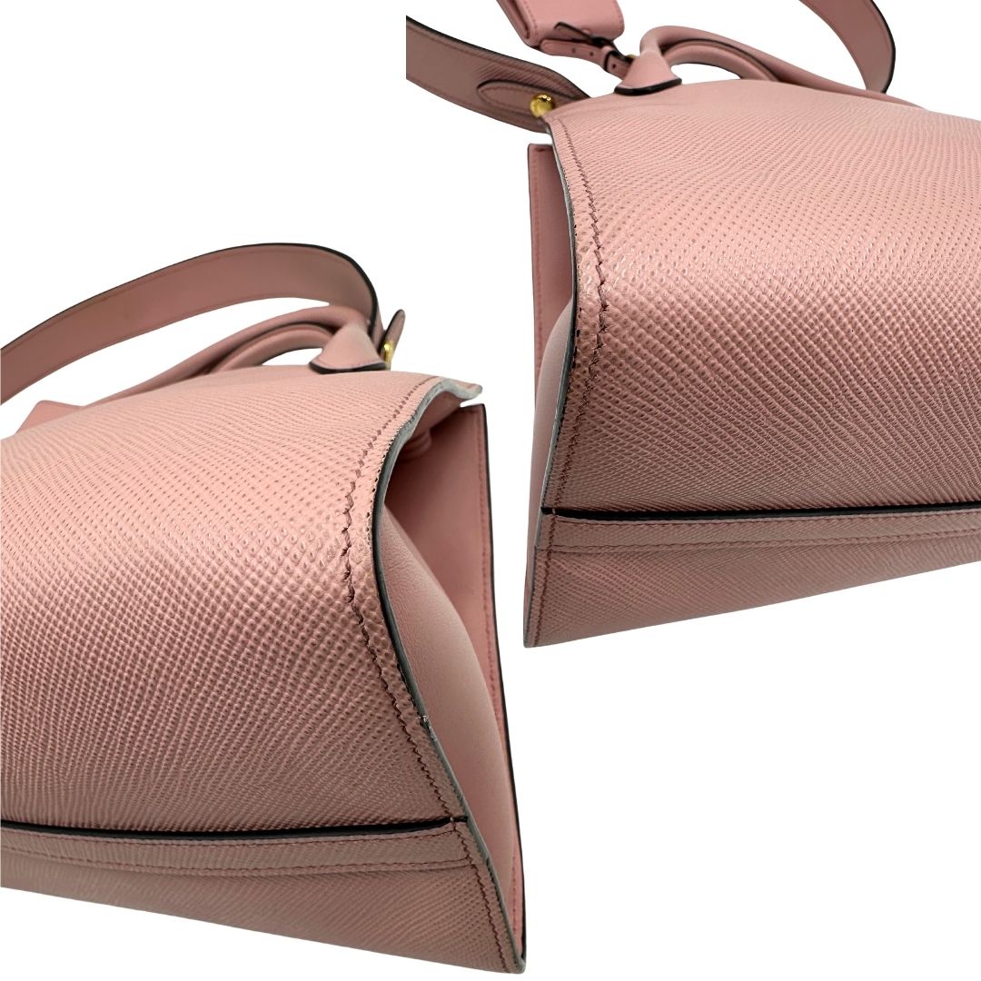Angoli di una borsa Prada rosa in pelle saffiano, dotata di un pratico charm con specchietto amovibile, usata, originale, second hand, in ottime condizioni.