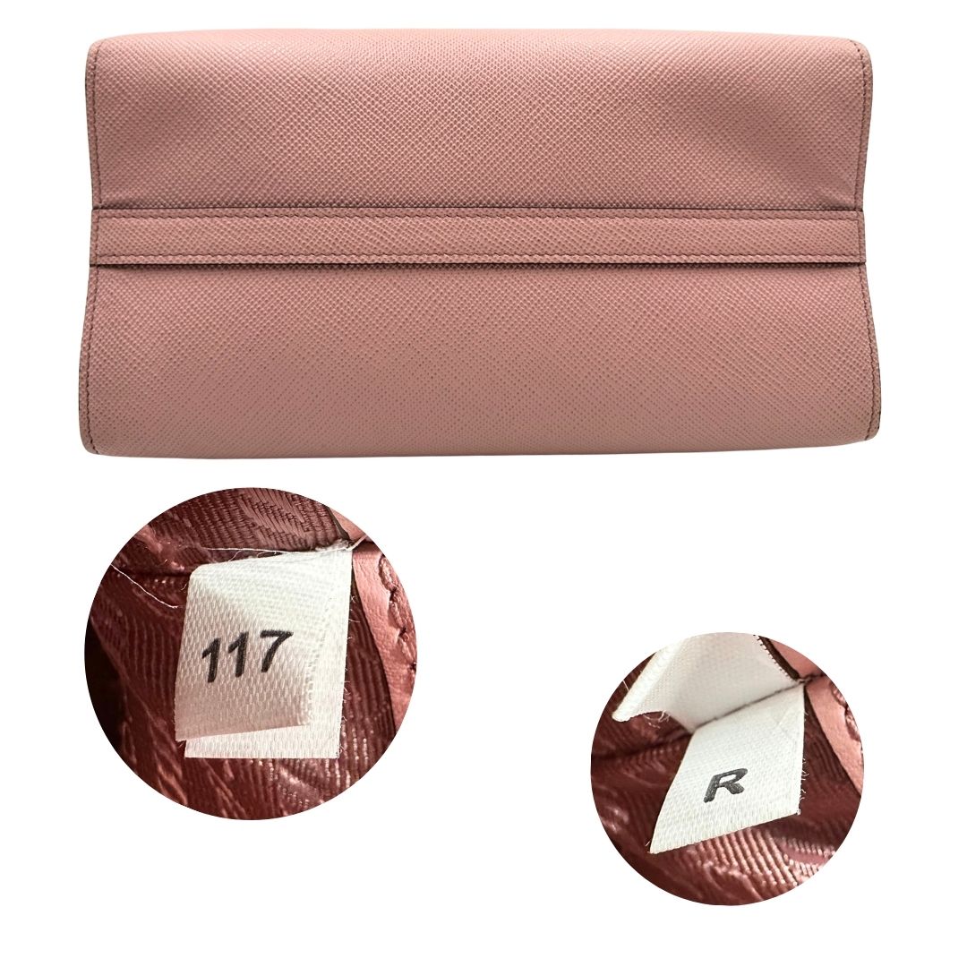 Base e codice di una borsa Prada rosa in pelle saffiano, dotata di un pratico charm con specchietto amovibile, usata, originale, second hand, in ottime condizioni.