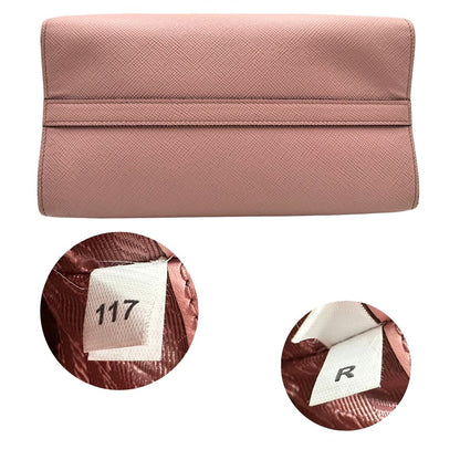 Base e codice di una borsa Prada rosa in pelle saffiano, dotata di un pratico charm con specchietto amovibile, usata, originale, second hand, in ottime condizioni.