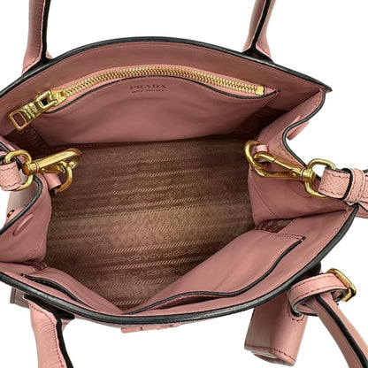 Interno di una borsa Prada rosa in pelle saffiano, dotata di un pratico charm con specchietto amovibile, usata, originale, second hand, in ottime condizioni.