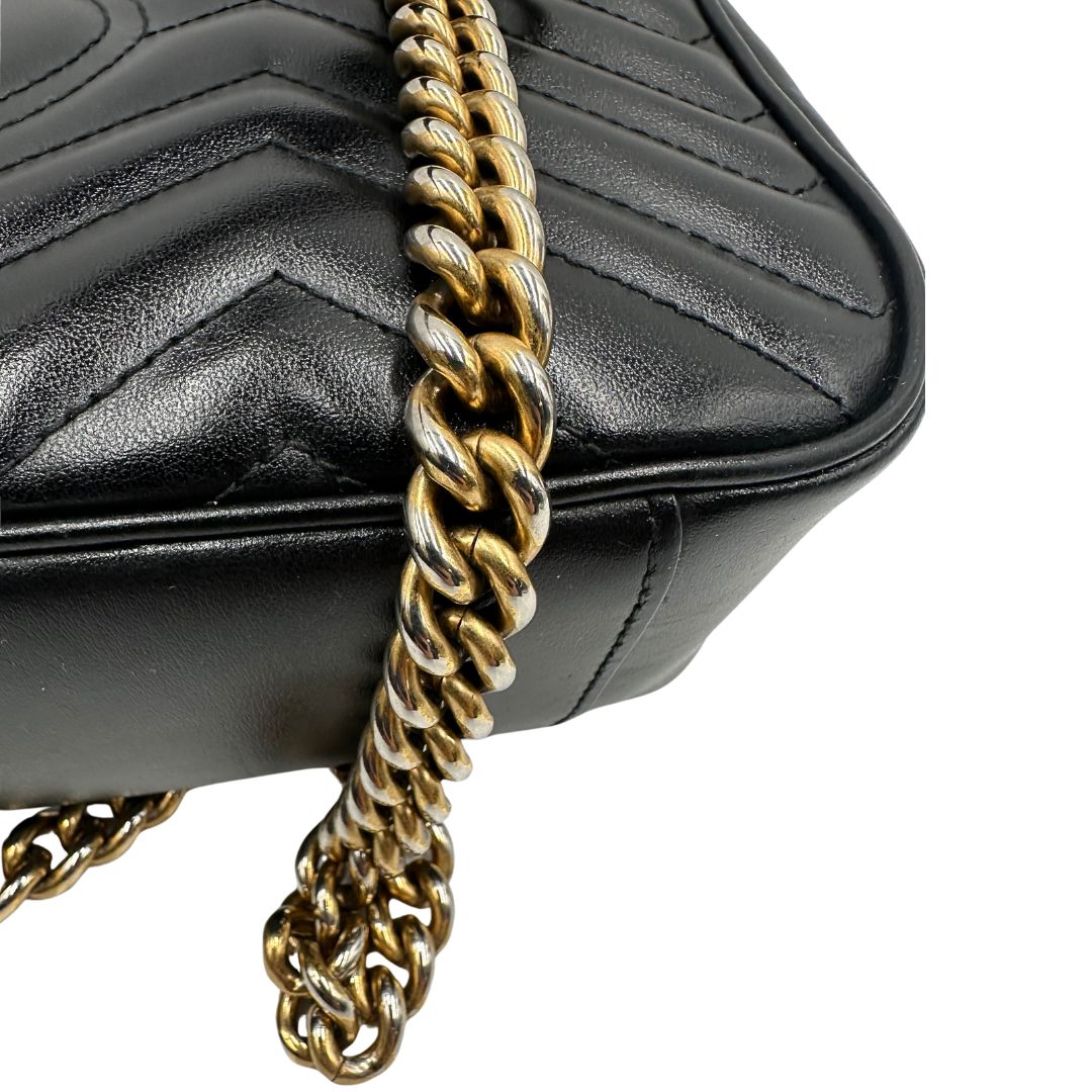 Metallo scolorito di una borsa Gucci Marmont nera in pelle con motivo chevron nella misura media, usata, originale, second hand, in ottime condizioni.