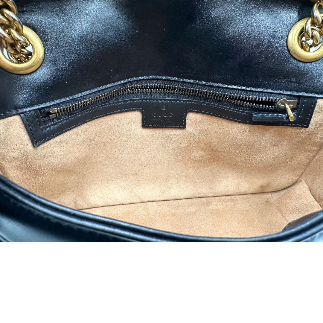 Interno di una borsa Gucci Marmont nera in pelle con motivo chevron nella misura media, usata, originale, second hand, in ottime condizioni.