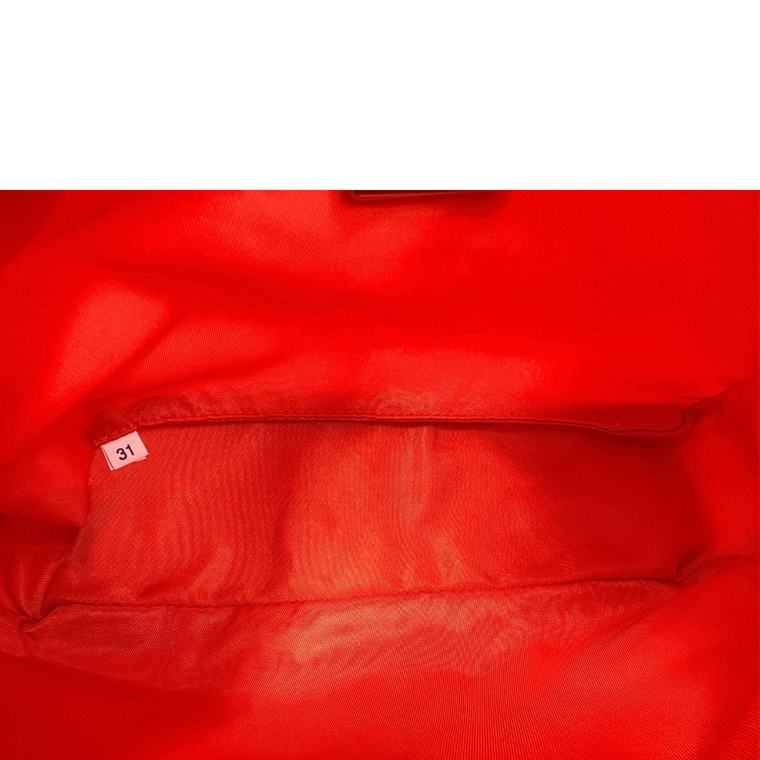 Interno di una borsa a spalla Prada in nylon arancione con dettagli in pelle Saffiano tono su tono e parti metalliche argentate, usata, originale, second hand, in condizioni eccellenti.