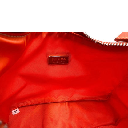 Interno di una borsa a spalla Prada in nylon arancione con dettagli in pelle Saffiano tono su tono e parti metalliche argentate, usata, originale, second hand, in condizioni eccellenti.