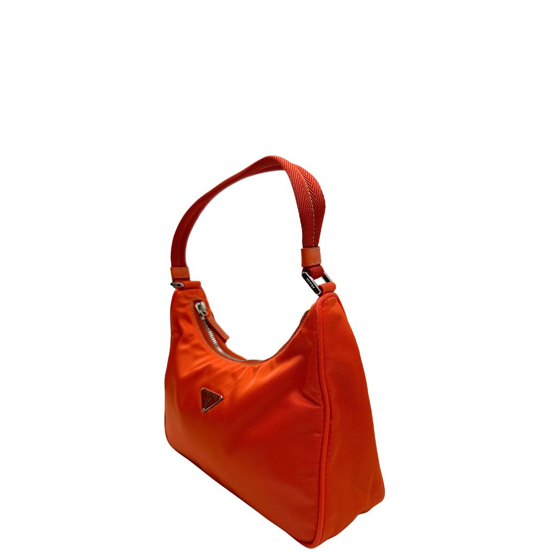 Laterale destro di una borsa a spalla Prada in nylon arancione con dettagli in pelle Saffiano tono su tono e parti metalliche argentate, usata, originale, second hand, in condizioni eccellenti.