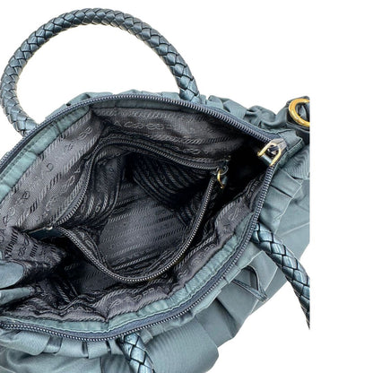 interno Borsa Prada in nylon nelle tonalità del blu petrolio, munita di doppi manici in pelle intrecciati, di lusso, originale, ottime condizioni, usata. 