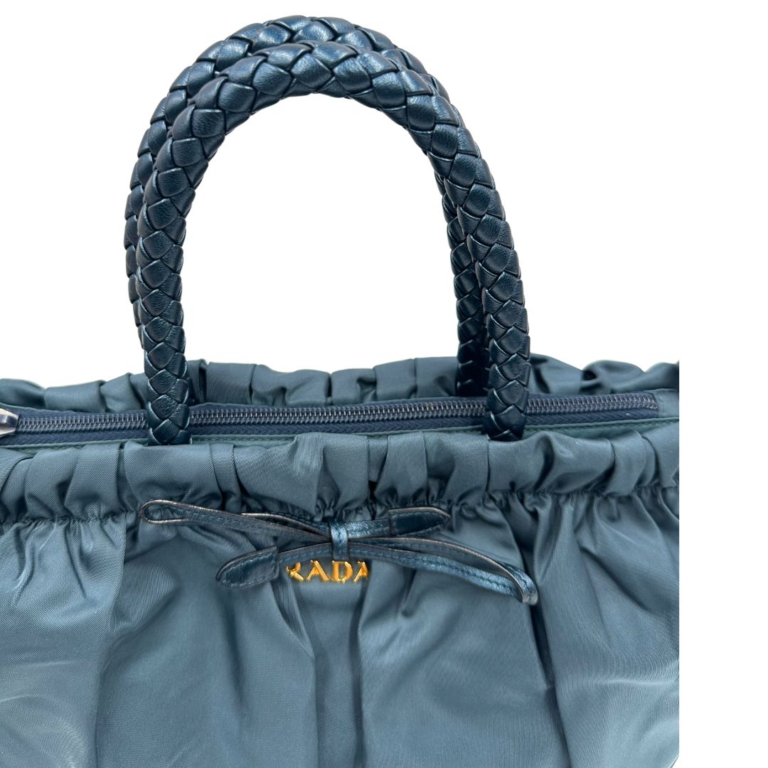 manici Borsa Prada in nylon nelle tonalità del blu petrolio, munita di doppi manici in pelle intrecciati, di lusso, originale, ottime condizioni, usata.